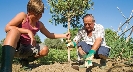 Photograph of two people planting a tree