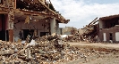 Photograph of homes destroyed with building debris all around