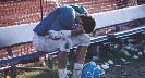 Photograph: a football player on bench hunched over with hands on face