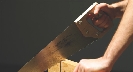 Photograph of a person cutting wood with a hand saw