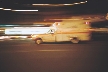 Photograph of an ambulance speeding along a street