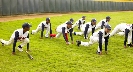 Photograph of baseball players in uniform doing stretching exercises