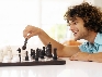 Photograph of a teenage boy moving a chess piece