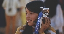 Photograph of a girl holding a first-place ribbon and trophy