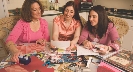 Photograph of three female women making a scrapbook