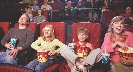 Photograph of a family at a movie theater, each with a bucket of popcorn