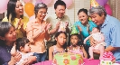 Photograph of people around a birthday cake with lit candles