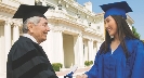 Photograph of a woman getting her diploma at graduation