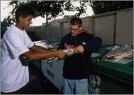 Teens sort trash and recycled items.