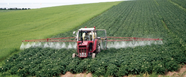 A farmer sprays pesticides on a field. Pesticides eventually “run off” into streams and groundwater, polluting the water we drink.