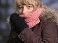 Photograph of a woman pulling her scarf over her mouth on a very cold day