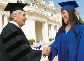 Photograph of a professor shaking the hand of a graduating student