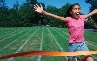 Photograph of a teenage girl running across a finish line