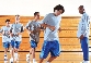 Photograph of teenage boys running in a school gym