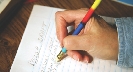Photograph of a person using an eraser at the top of a pencil