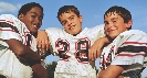 Photograph of three boys in football uniforms