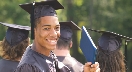 Photograph of a teenage boy in a graduation cap and gown smiling