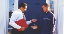 Photograph of two people standing at the entrance of a building