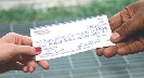 Photograph of a check passing from one person to another
