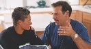 Photograph of an adult talking to a teenager in a home setting