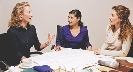 Photograph of three women at a conference table