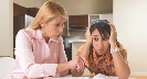 Photograph: woman and sad girl doing homework (girl with hands on either side of head)