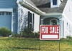 Photograph of for sale sign on front lawn of a home