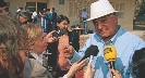 Photograph of several reporters with microphones interviewing someone