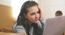 Photograph of a student staring at a sheet of paper she is holding