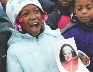 Photograph of a young girl holding a photo of Rosa Parks