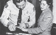 Photograph of Rosa Parks being fingerprinted by a police officer