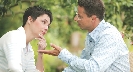 Photograph of a man talking as a woman listens