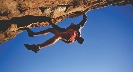 Photograph of a person climbing a dangerous, rock cliff