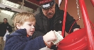 Photograph of a child placing money in a collection container