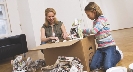 Photograph of two people unpacking a cardboard box