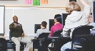 Photograph of a teacher calling on a student who has their hand raised