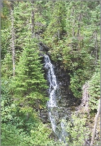 The waterfall rushed swiftly to the river.