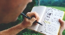 Photograph of someone writing in a journal/notebook