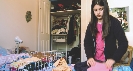 Photograph of a girl putting clothes away in her room