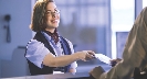 Photograph of a ticket agent handing tickets to someone