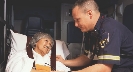 Photograph of a firefighter attending to a woman