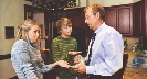 Photograph of a man giving money to teenagers who have their hands out