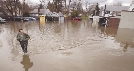 Photograph of a person walking through a flooded town