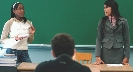 Photograph of two students at the front of a classroom having a debate