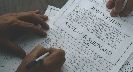 Photograph of close up of a person signing a petition