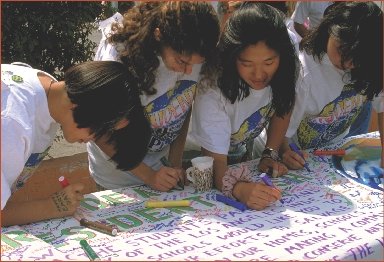 Students urge people to protect the environment by adding their signatures to a petition.