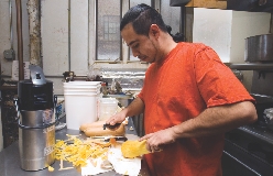 A student volunteer helps prepare a meal at First Slice.