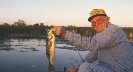 Photograph of an adult fisherman with a fish