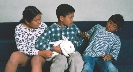 Photograph of children with a rabbit. One child pulls away, anxious about petting it.