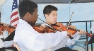 Photograph of two boys playing violins